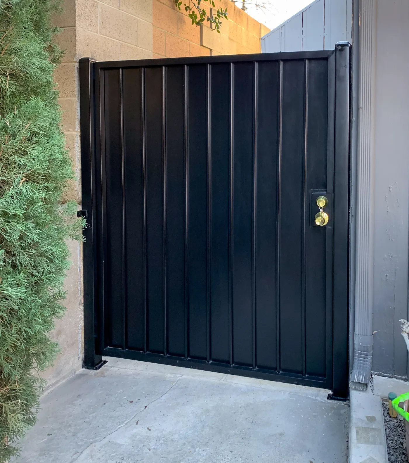 Black vertical panel metal gate with keyed latch